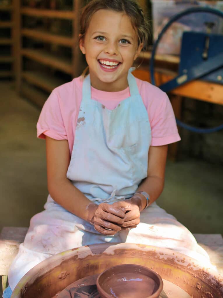 cute camp girl making pottery