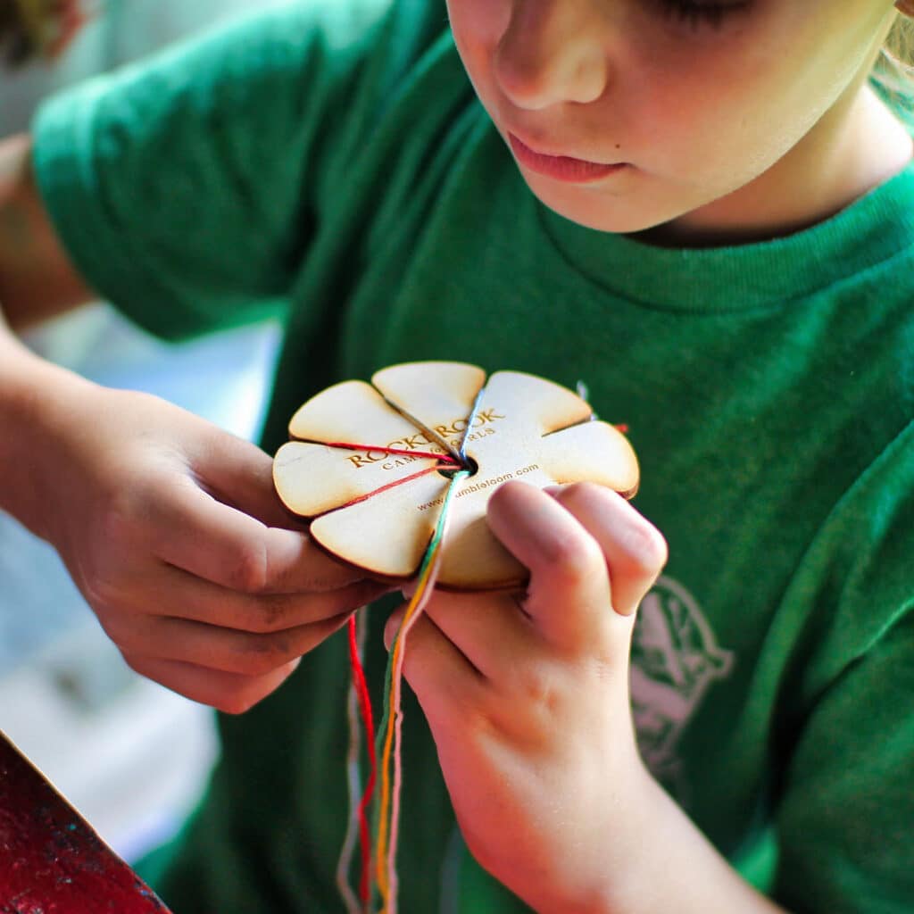 kid making string bracelet